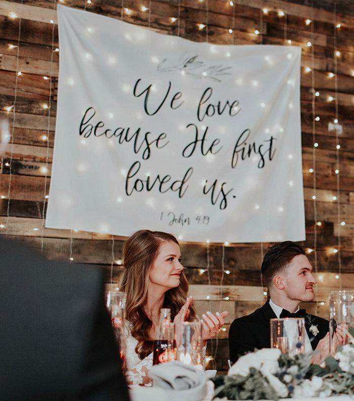 We Love Because He First Loved Us | Christian Wedding Bible Verse Backdrop Decorations - Blushing Drops